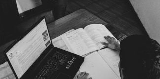 Duab grayscale ntawm tus neeg tuav phau ntawv