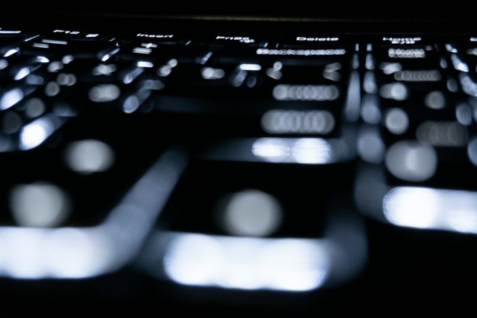 Photo by Zulfugar Karimov Close-up of a backlit keyboard in the dark.