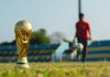 selective focus photography of gold-colored trophy on grass field during daytime