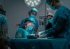 The Surgeon’s Body Is the Bottleneck Nobody Budgets For a group of doctors performing surgery on a patient